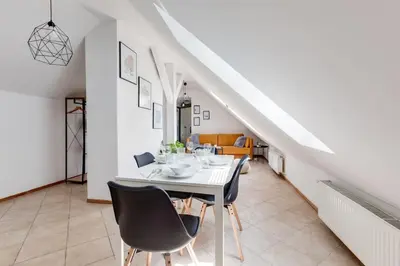 a dining room with a white table and chairs at Cozy & Quiet Center Attic with Castle view - vtuB in Prague