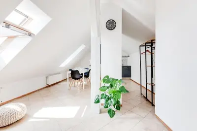 a living room with a table and a plant at Cozy & Quiet Center Attic with Castle view - vtuB in Prague