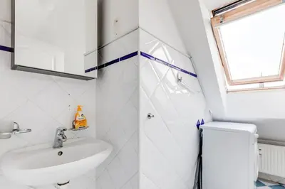 a white bathroom with a sink and a mirror at Cozy & Quiet Center Attic with Castle view - vtuB in Prague