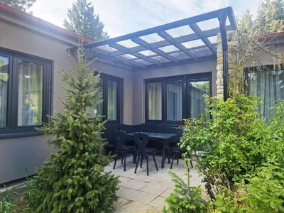 a patio with a table and chairs under a pergola at Relax apartmán Pod Javorem in Kladno