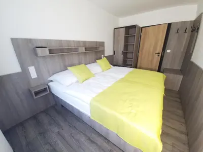 a bedroom with a large bed with yellow sheets at Relax apartmán Pod Javorem in Kladno