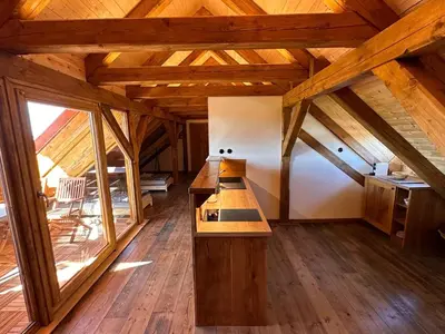 a kitchen with wooden floors and a wooden ceiling at Farma Bláto - Apartmány Sýpka a glamping in Uhlířské Janovice