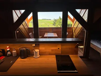 a view of a room with a table and a window at Farma Bláto - Apartmány Sýpka a glamping in Uhlířské Janovice