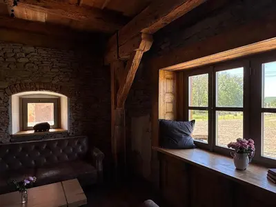 a living room with a couch and a window at Farma Bláto - Apartmány Sýpka a glamping in Uhlířské Janovice