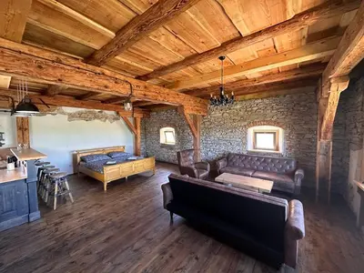 a living room with a couch and a table at Farma Bláto - Apartmány Sýpka a glamping in Uhlířské Janovice