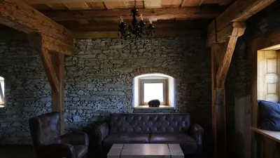 a living room with a couch and a window at Farma Bláto - Apartmány Sýpka a glamping in Uhlířské Janovice