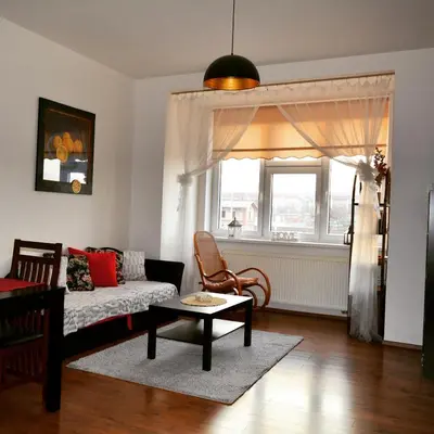a living room with a couch and a window at MM Apartment Argentinska in Prague