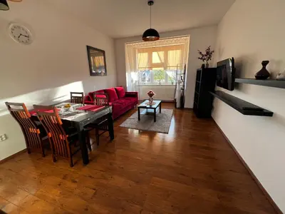 a living room with a red couch and a table at MM Apartment Argentinska in Prague