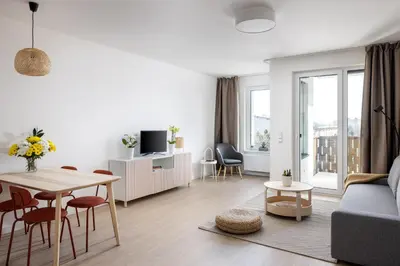 a white living room with a table and a couch at Stay2gether Japandi Homestay for 4 - Metro B Luka in Prague