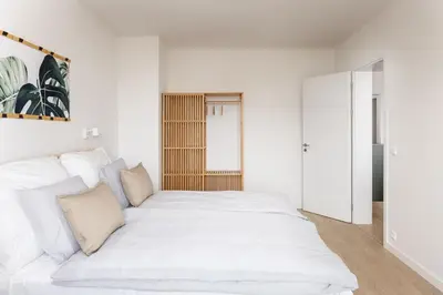 a white bedroom with a large white bed at Stay2gether Japandi Homestay for 4 - Metro B Luka in Prague