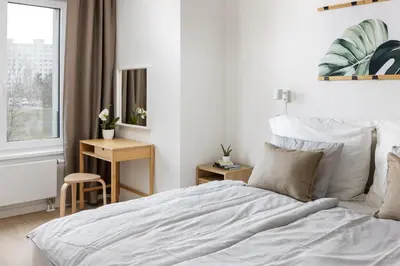 a white bedroom with a bed and a window at Stay2gether Japandi Homestay for 4 - Metro B Luka in Prague