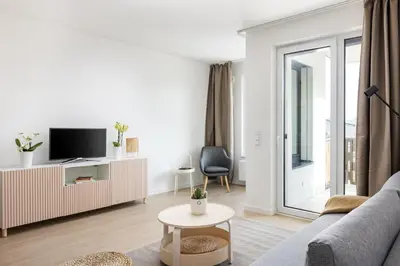 a living room with a couch and a tv at Stay2gether Japandi Homestay for 4 - Metro B Luka in Prague