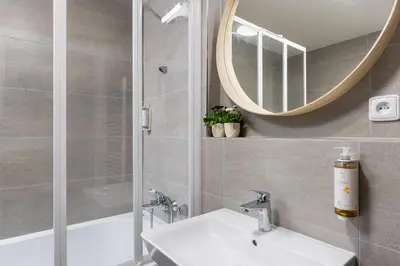 a bathroom with a sink and a mirror and a tub at Stay2gether Japandi Homestay for 4 - Metro B Luka in Prague