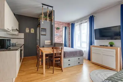 a kitchen and dining room with a table and a bedroom at Centrum Royal Studio in Prague