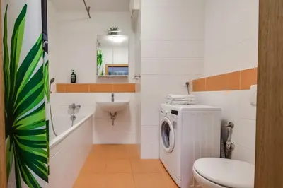 a bathroom with a washing machine and a sink at Centrum Royal Studio in Prague