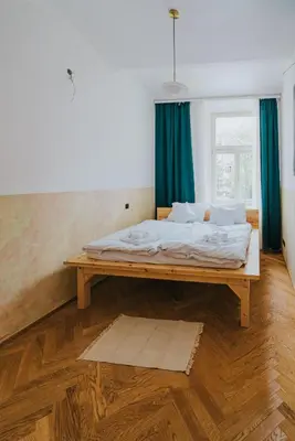 a bed in a room with a wooden table at Bohemian Experience in Prague