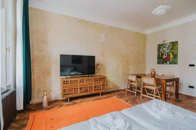 a bedroom with a television and a dining room table at Bohemian Experience in Prague