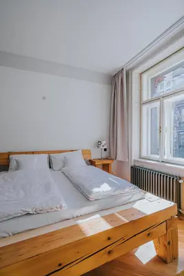 a bed with a wooden frame in a room with a window at Bohemian Experience in Prague