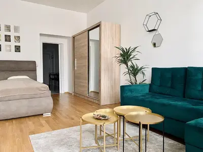 a living room with a green couch and two tables at Stylish retreat in a lively area in Prague