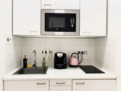 a kitchen counter with a sink and a microwave at Stylish retreat in a lively area in Prague