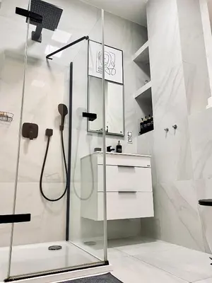 a shower with a glass door in a bathroom at Stylish retreat in a lively area in Prague
