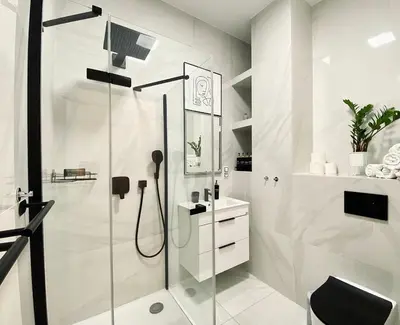 a white bathroom with a shower and a sink at Stylish retreat in a lively area in Prague