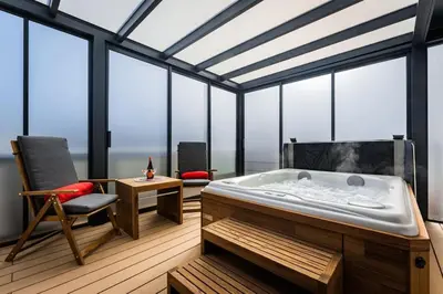 a large room with a bath tub and a chair at Romantic wellness apartment in Prague