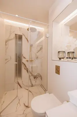 a bathroom with a toilet and a glass shower at Stylish new apartment in Prague with A/C in Prague