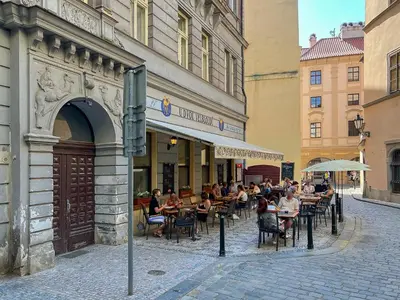 a group of people sitting at tables outside a building at Stylish new apartment in Prague with A/C in Prague
