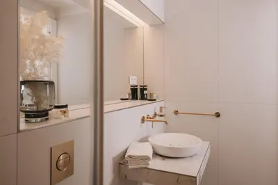 a white bathroom with a sink and a mirror at Stylish new apartment in Prague with A/C in Prague