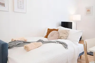 a white bed with pillows and blankets on it at Rentero Varsavska Apartment Residence, Prague in Prague