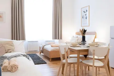 a living room with a table and chairs and a bed at Rentero Varsavska Apartment Residence, Prague in Prague