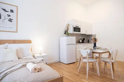 a bedroom with a bed and a table and a kitchen at Rentero Varsavska Apartment Residence, Prague in Prague