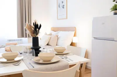 a dining room with a table with chairs and a couch at Rentero Varsavska Apartment Residence, Prague in Prague