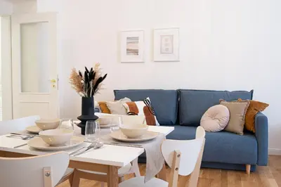 a living room with a blue couch and a table and chairs at Rentero Varsavska Apartment Residence, Prague in Prague