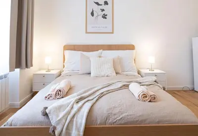 a bedroom with a large bed with towels on it at Rentero Varsavska Apartment Residence, Prague in Prague