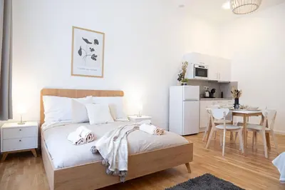 a bedroom with a bed and a kitchen with a table at Rentero Varsavska Apartment Residence, Prague in Prague