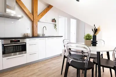 a kitchen with white cabinets and a table with chairs at Rentero Marilyn Monroe Apartment with AC in Prague center in Prague
