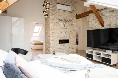 a living room with a brick wall and a tv at Rentero Marilyn Monroe Apartment with AC in Prague center in Prague