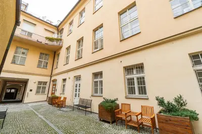 a courtyard in a building with chairs and tables at Rentero Marilyn Monroe Apartment with AC in Prague center in Prague