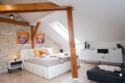 a bedroom with a white bed and a brick wall at Rentero Marilyn Monroe Apartment with AC in Prague center in Prague