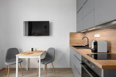 a kitchen with a table and two chairs and a sink at Apartment near the subway with a terrace in Prague