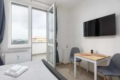 a bedroom with a bed and a table and a tv at Apartment near the subway with a terrace in Prague