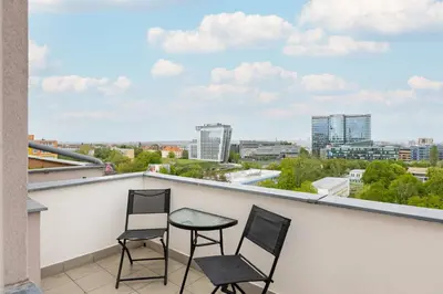two chairs and a table on a balcony with a view at Apartment near the subway with a terrace in Prague