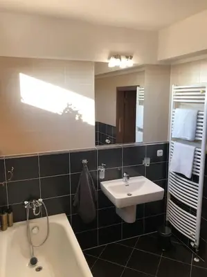a bathroom with a sink and a tub and a mirror at Apartment Little Hill in Prague