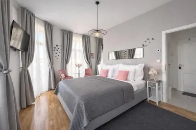 a bedroom with a bed with pink pillows and a mirror at Praha 1 Florenc Hlavní mesto Romantic Apartments in Prague