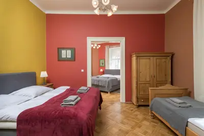 a bedroom with two beds and a red wall at Liliova Apartments in Prague
