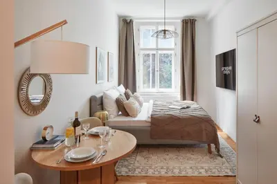a bedroom with a bed and a table and a window at Prague Days - Studio with Outdoor Seating close to Vyšehrad in Prague