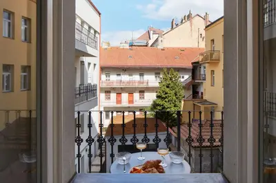 a table with wine glasses and food on a balcony at Prague Days - Studio with Outdoor Seating close to Vyšehrad in Prague