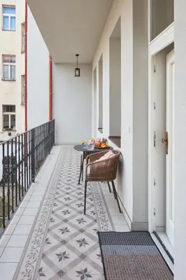 a balcony with a table and chairs on a floor at Prague Days - Studio with Outdoor Seating close to Vyšehrad in Prague